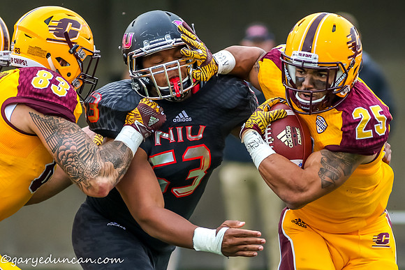 Central Michigan Chippewas running back DEVON SPALDING (25) fends off a tackle attempt by Northern Illinois Huskies defensive end QUINTIN WYNNE (53) in the first half during NCAA football game action